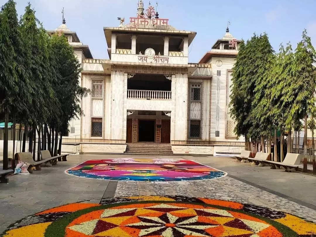 Muktidham Mandir in Maharashtra showcasing white marble temple architecture with a spacious courtyard and colorful rangoli decorations, a revered spiritual site included in Maharashtra tour packages