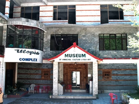 Museum of Himachal Culture & Folk Art in Manali featuring stone façade building with red-roofed entrance and traditional wooden doorway.