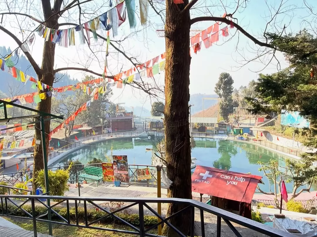 Mussoorie Lake scenic boating spot with calm waters, hillside views and colorful flags in Uttarakhand