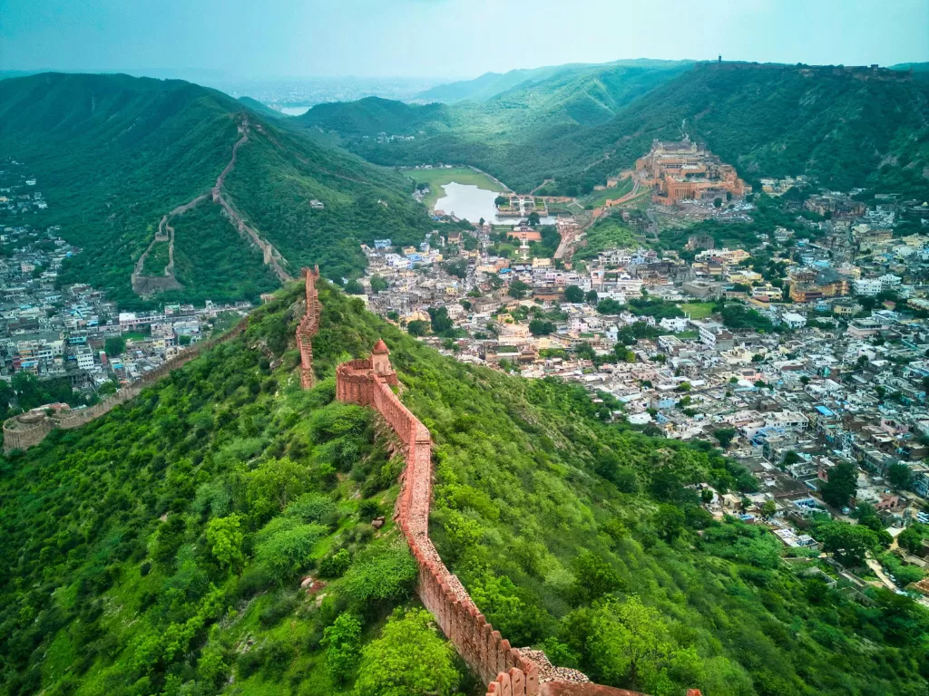 Amber Fort view from Nahargarh Sunset Point Jaipur during clear day, featuring Great Wall Maota Lake and Aravalli hills, perfect romantic experience Rajasthan tour packages.