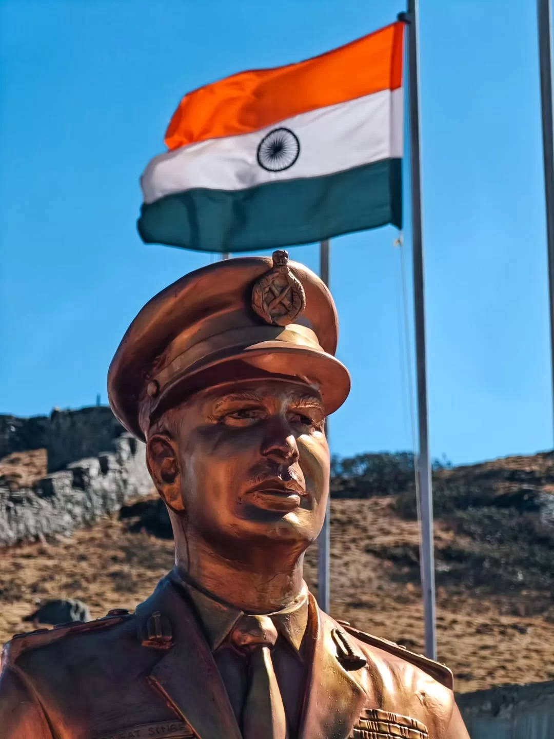 Statue of an Indian Army officer with the national flag flying high in Gangtok, a patriotic landmark proudly featured in Sikkim tour packages.