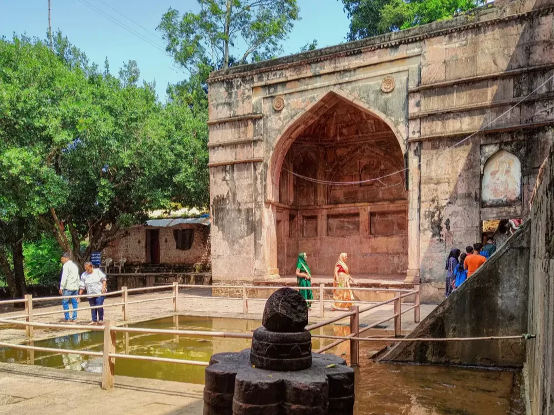 Nilkanth Mahal and Temple in Mandu, Madhya Pradesh, featuring historic archways and a sacred water tank surrounded by greenery, a revered heritage site included in Madhya Pradesh tour packages