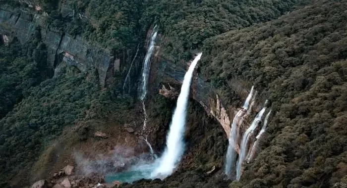 Nohkalikai Falls in Cherrapunji, Meghalaya, India’s tallest plunge waterfall cascading dramatically into a turquoise pool surrounded by lush green cliffs.