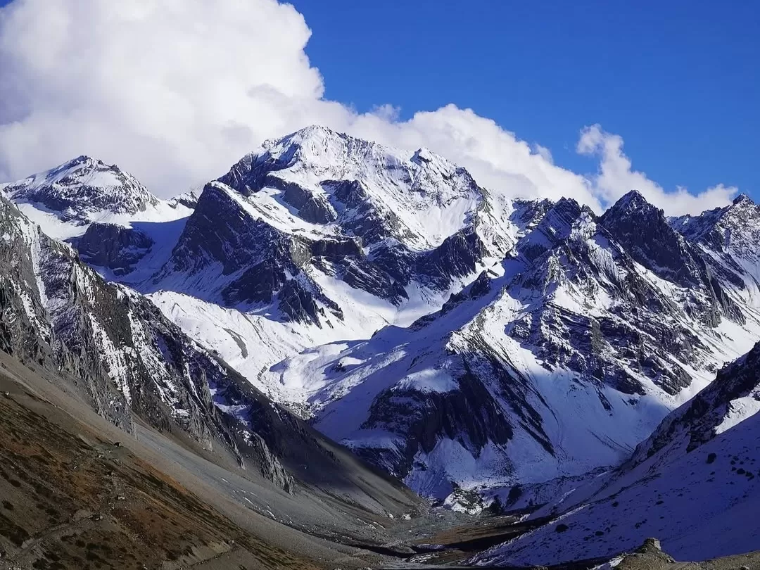 Om Parvat snow covered sacred Himalayan peak with dramatic mountain landscape in Uttarakhand tour packages.