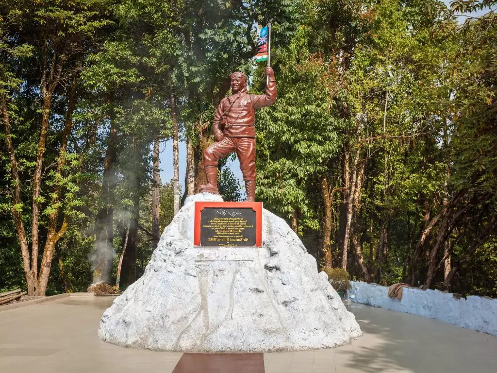 Tenzing Norgay statue at Padmaja Naidu Himalayan Zoological Park in Darjeeling during sunny daytime, featuring forest backdrop, perfect Sikkim tour package