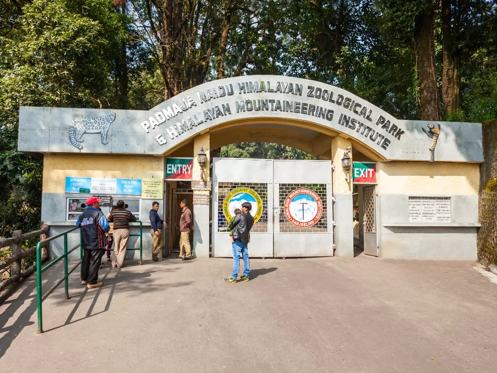 Entrance gate of Padmaja Naidu Himalayan Zoological Park in Darjeeling during daytime, featuring tourists and forest backdrop, perfect family Sikkim tour package