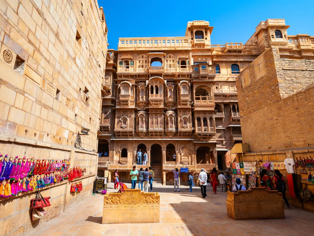 Patwon Ki Haveli Jaisalmer courtyard view sandstone buildings jharokhas tourists colorful handicraft stalls featured in Rajasthan tour packages