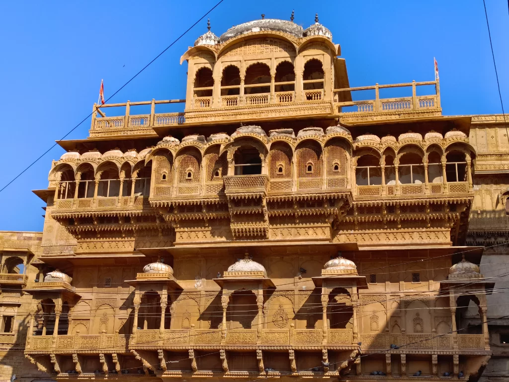 Patwon Ki Haveli Jaisalmer sandstone architecture intricate jharokhas balconies domes blue sky featured in Rajasthan tour packages