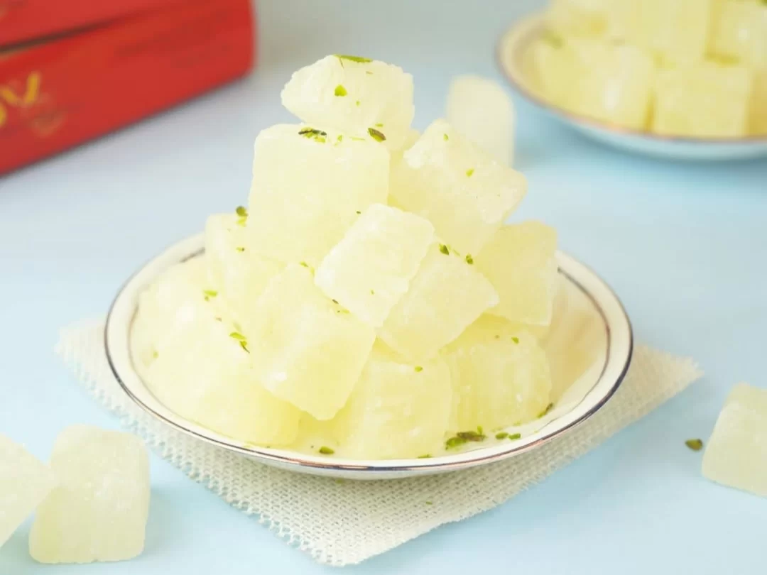 Petha, a famous Agra sweet made from ash gourd, known for its translucent look, soft bite, and mild sugary sweetness.