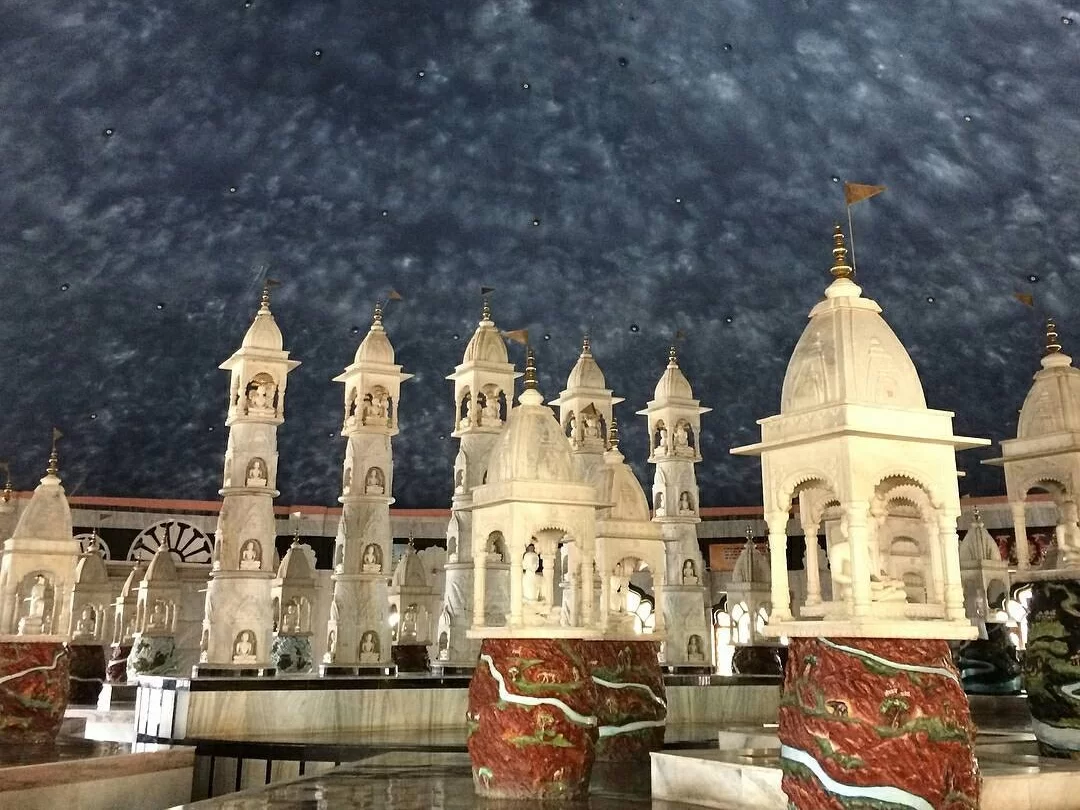 Intricate white marble shrines at Pisanhari Ki Madiya in Jabalpur, Madhya Pradesh, showcasing detailed carvings and temple spires, a prominent Jain pilgrimage site featured in Madhya Pradesh tour packages
