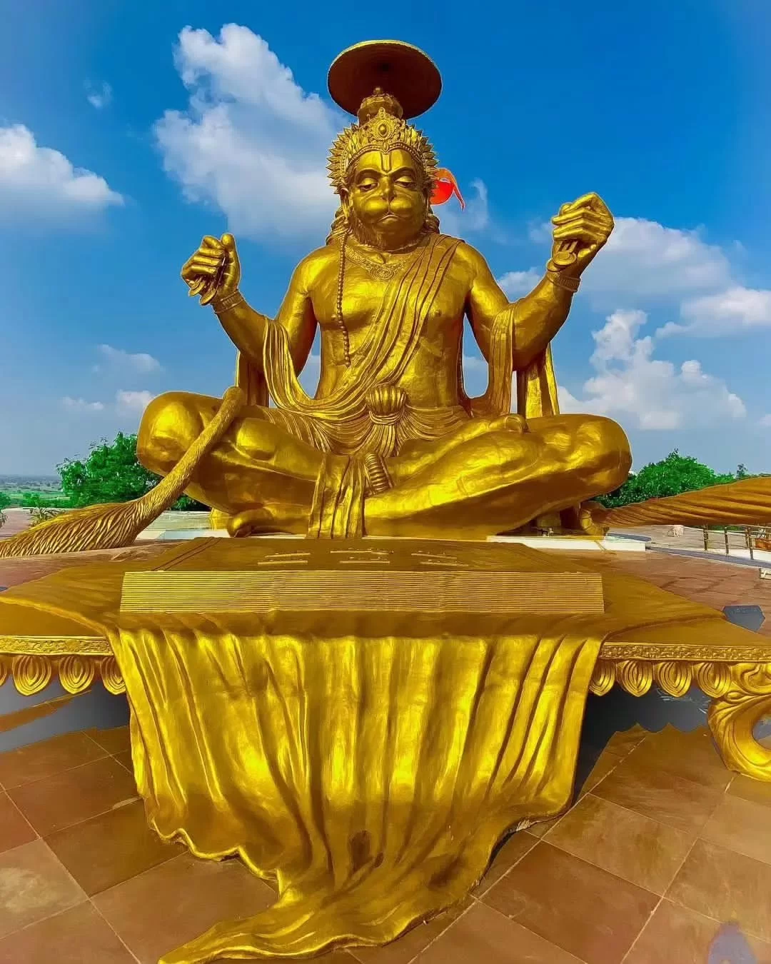 72-ft golden Hanuman statue at Pitra Parvat Indore during clear daylight, featuring meditative pose saffron flag, perfect spiritual Madhya Pradesh tour package.
