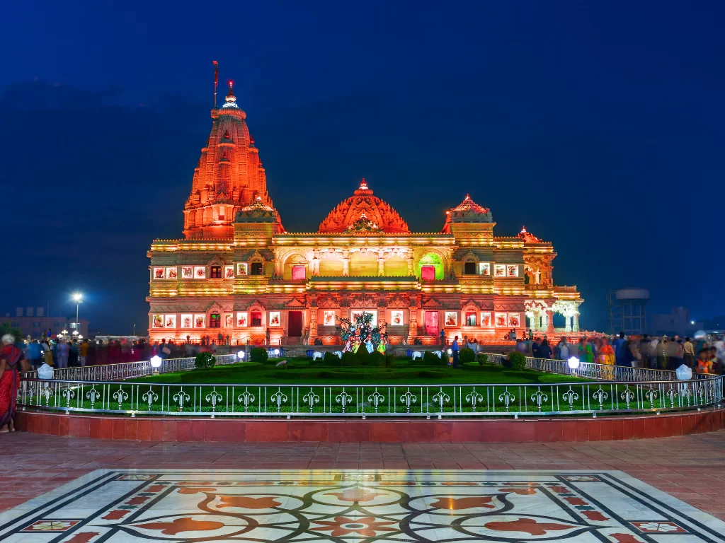 Prem Mandir at Vrindavan during night illumination, featuring pink sandstone architecture, golden spires, festive lights, perfect spiritual experience with Mathura Vrindavan tour package. 
