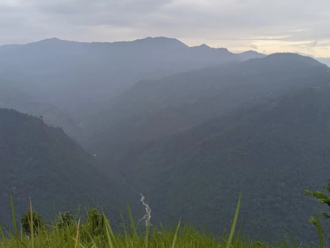 Pujay Dara View Point in Kalimpong, West Bengal, offering panoramic views of mist-covered hills and a winding river valley, a scenic stop often included in West Bengal tour packages.