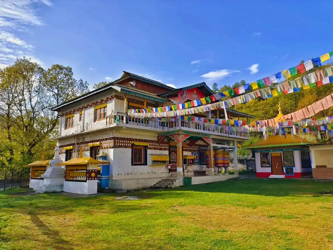 Puranabasti Gompa in Shergaon during daylight, featuring Buddhist monastery and colorful prayer flags, perfect spiritual experience, Arunachal Pradesh tour packages.