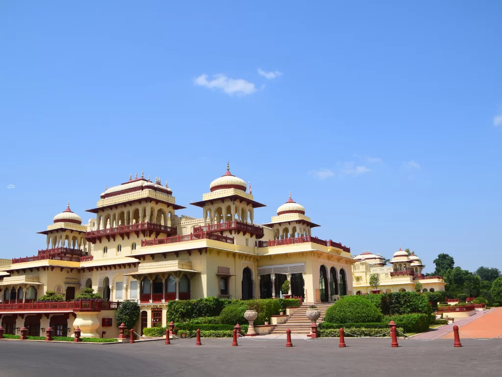 Rambagh Palace Jaipur pink Rajasthani architecture domes balconies gardens blue sky luxury heritage hotel Taj Rajasthan tour packages.
