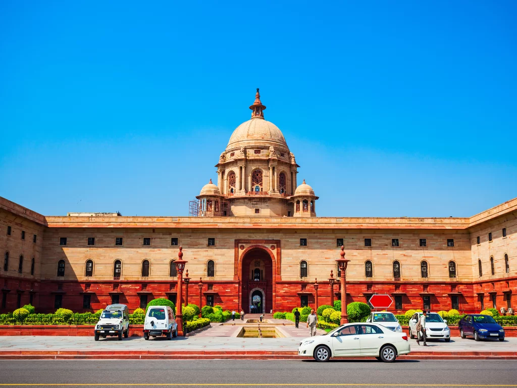 Rashtrapati Bhavan at New Delhi on sunny day, featuring sandstone dome and forecourt, perfect heritage Delhi tour package.