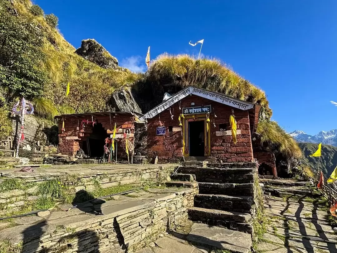 Rudranath Temple in Uttarakhand under clear blue sky, ancient stone shrine in Himalayas and sacred trekking destination featured in Uttarakhand tour packages