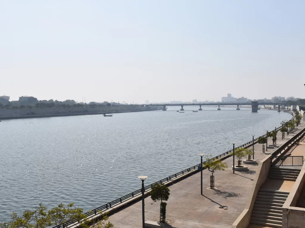 Riverfront promenade at Sabarmati Riverfront Ahmedabad during daylight, featuring bridges and Sabarmati River, perfect romantic Gujarat tour package.