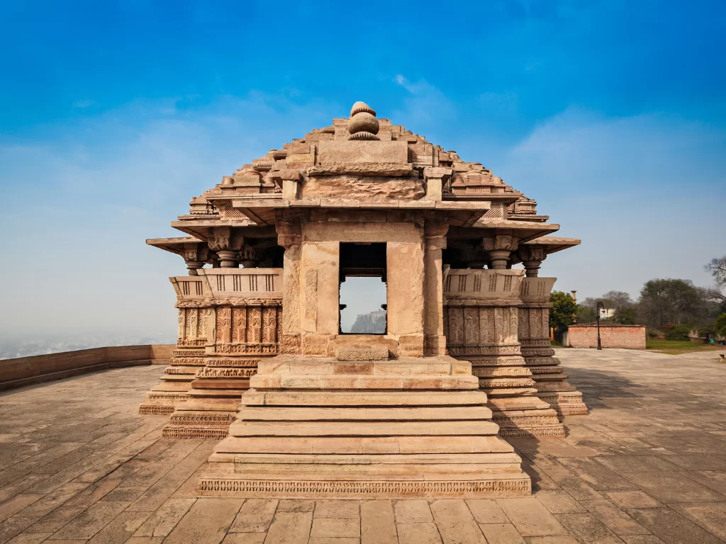 Sasbahu Bahu Temple at Gwalior Fort under clear skies, featuring carved dome and elevated platform, perfect heritage experience with Madhya Pradesh tour packages.