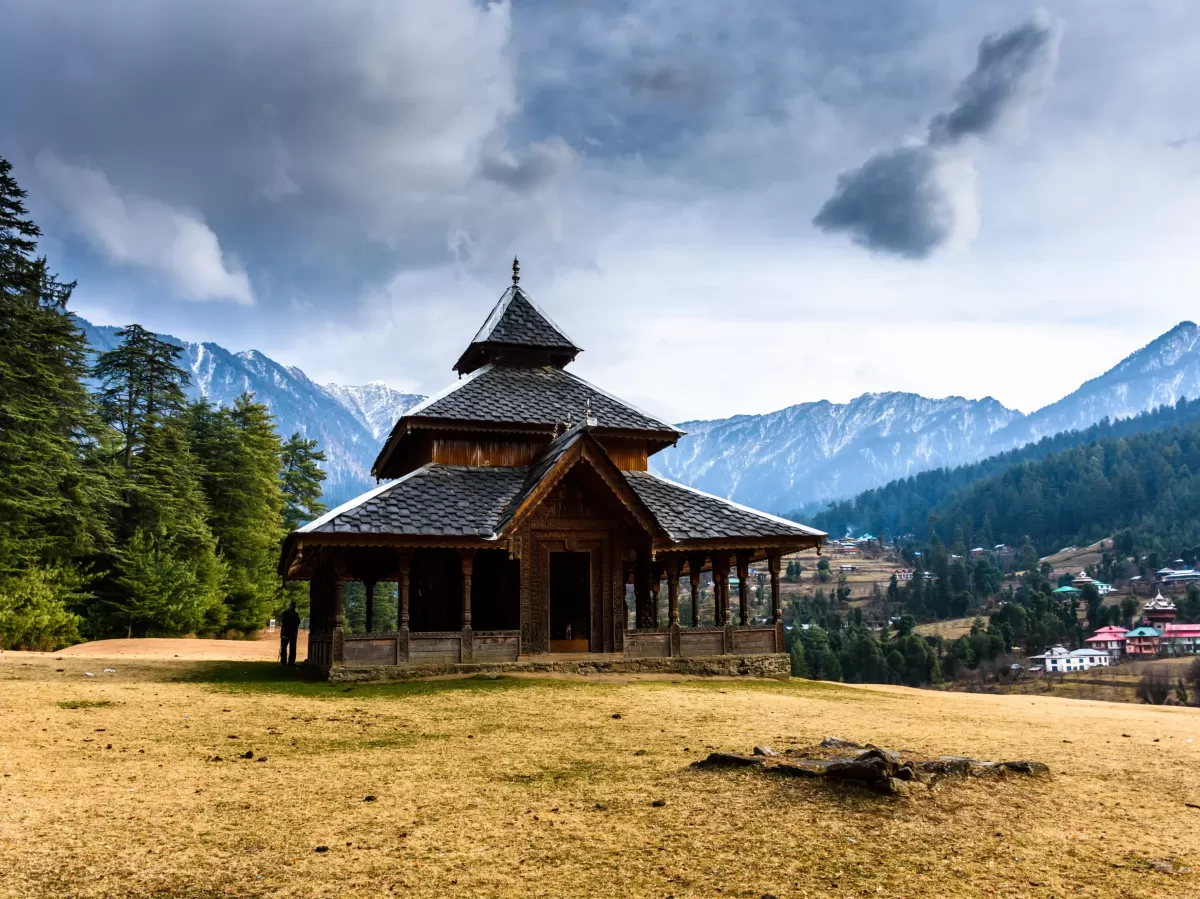 Shangchul Mahadev Temple at Shangarh Meadows during cloudy weather, featuring wooden pagoda pine forests snow peaks, perfect adventure experience Himachal Pradesh tour package.