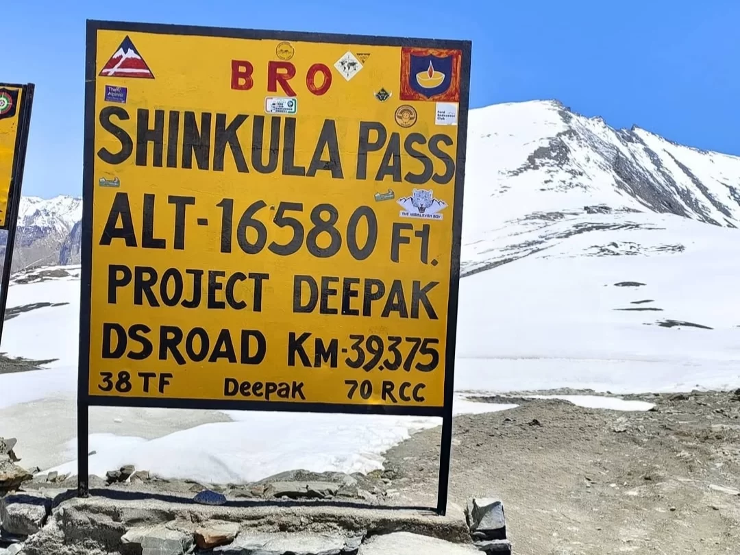BRO Shinkula Pass sign Alt 16580 ft Lahaul Spiti Himachal Pradesh sunny day, snow peaks Zanskar ranges; perfect Ladakh Manali tour package