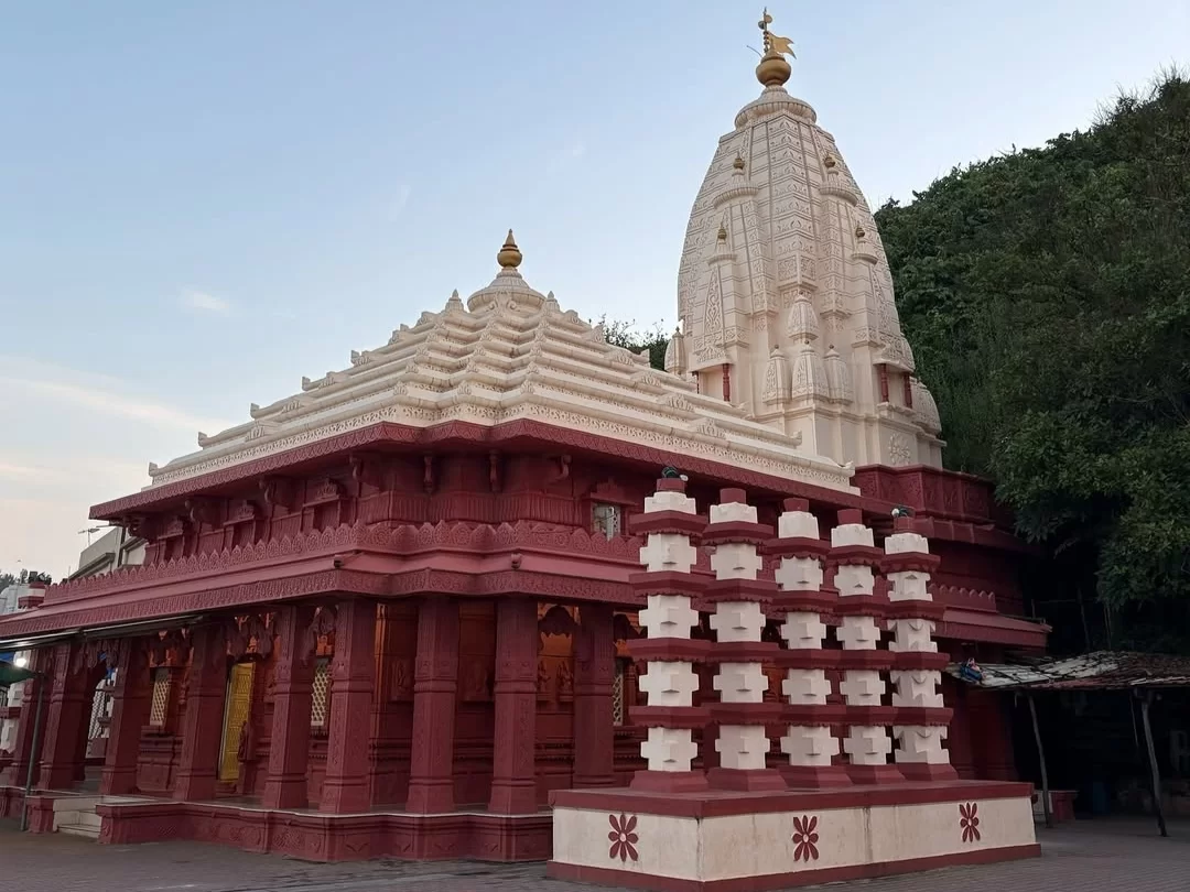 Shree Ganpatipule Mandir in Maharashtra featuring the iconic white temple spire and red stone architecture near the Arabian Sea coast, a major pilgrimage site included in Maharashtra tour packages