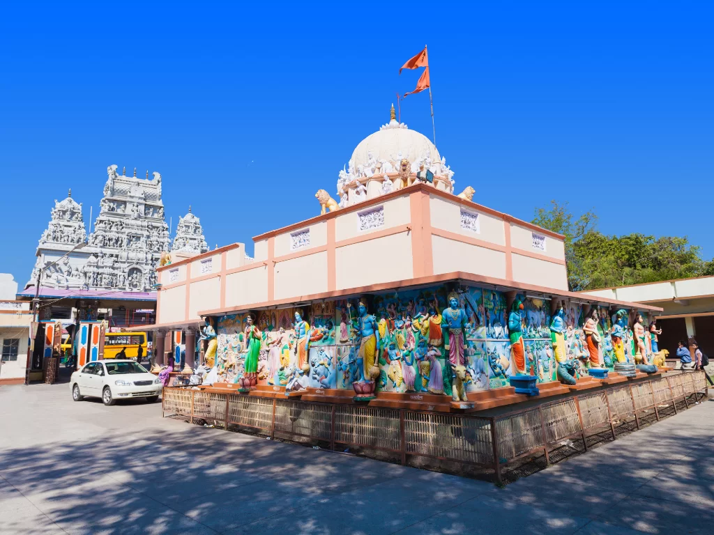 Shree Annapurna Temple at Indore during clear daylight, featuring white gopuram colorful deity statues saffron flag, perfect spiritual Madhya Pradesh tour package.