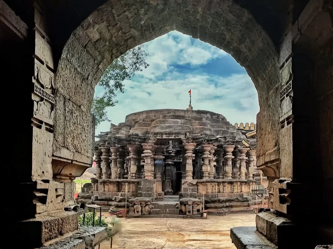  Shri Kopeshwar Temple in Maharashtra showcasing intricate stone carvings and circular mandapa architecture viewed through a historic archway, a remarkable heritage site included in Maharashtra tour packages