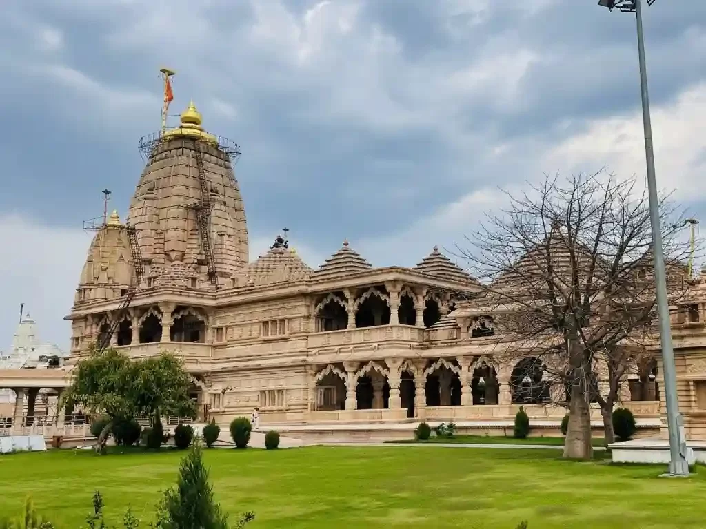 Shri Sanwaliyaji Seth Prakatya Mandir Chittorgarh Ornate "Lord Krishna" temple featuring pink sandstone architecture, grand marble pillars, and intricate gold-foil murals depicting celestial scenes Rajasthan.