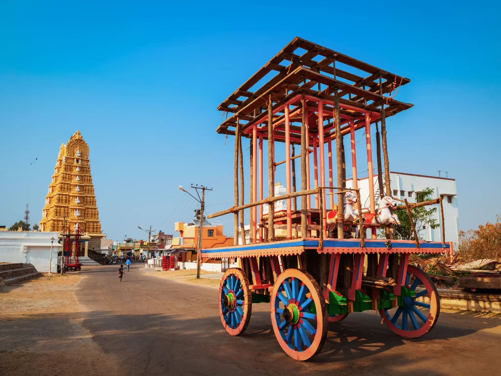 Temple chariot at Sri Chamundeshwari Temple in Mysore during sunny daytime, featuring colorful wooden ratha and gopuram, perfect Karnataka tour package