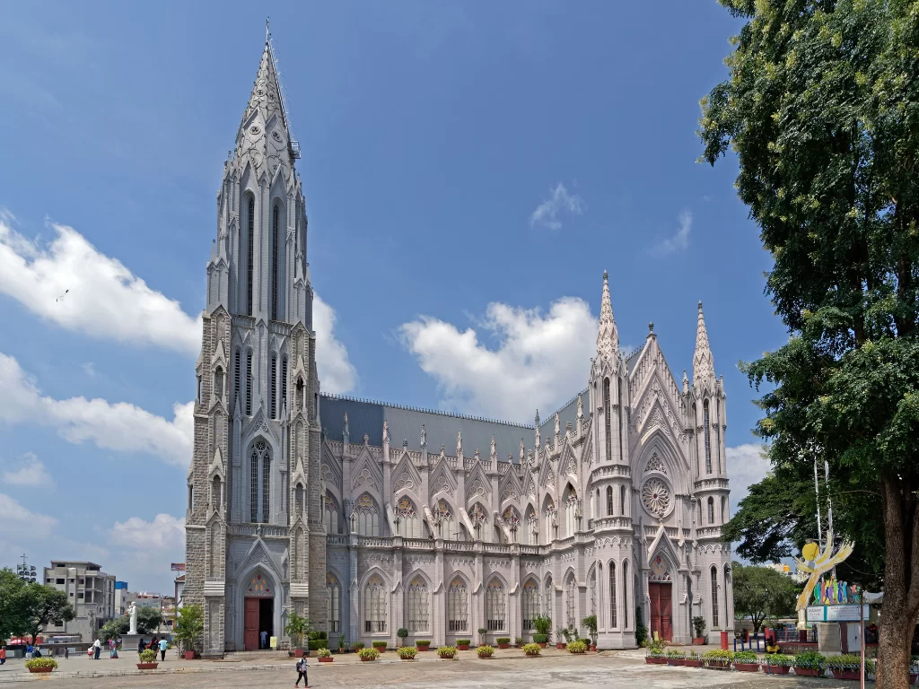 St. Philomena's Cathedral in Mysore during clear daytime, featuring grand neo-gothic facade and open courtyard, perfect heritage Karnataka tour package