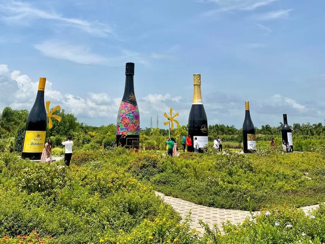 Sula Vineyards in Maharashtra featuring giant wine bottle installations set amid lush vineyards and landscaped gardens, a popular wine tourism destination included in Maharashtra tour packages