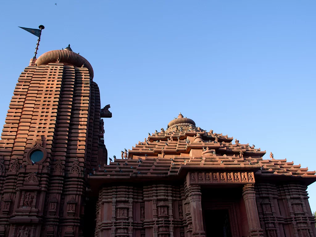 Sun Temple Gwalior during clear afternoon, featuring towering rekha deul vimana and stepped jagamohana with intricate red sandstone carvings, perfect heritage experience in Madhya Pradesh tour package.