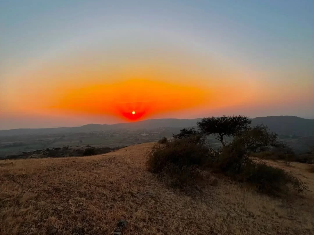 Sunset view from Sunset Point in Matheran, Maharashtra, with the sun dipping below rolling hills and a golden sky, a popular viewpoint featured in Maharashtra tour packages.
