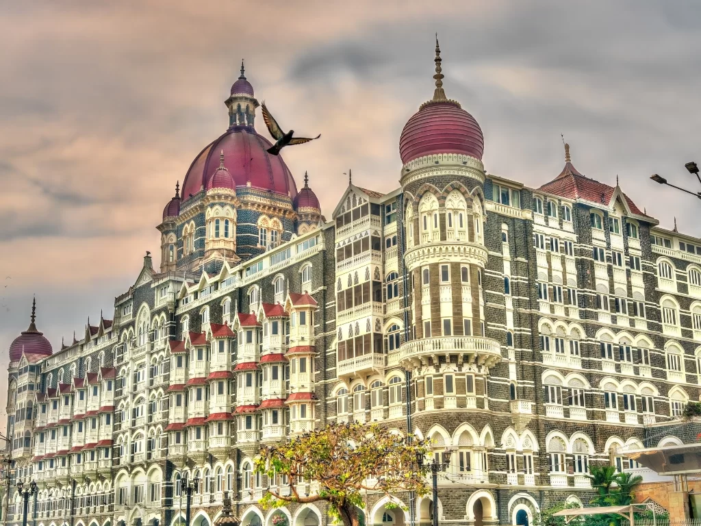 Taj Mahal Palace Mumbai golden hour dramatic sky flying bird Indo-Saracenic domes heritage luxury Colaba Gateway of India, perfect Mumbai tour package.