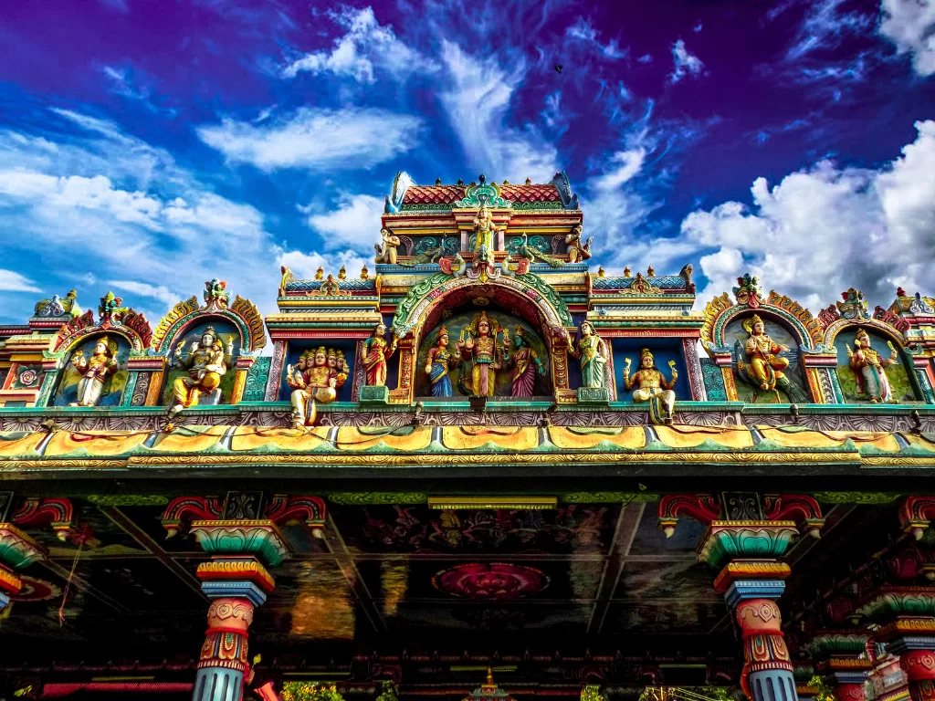 Tapovan Temple Vadodara showcases vibrant Dravidian-style gopuram with intricate deity carvings under dramatic skies, spiritual heritage perfect for Gujarat tour packages.