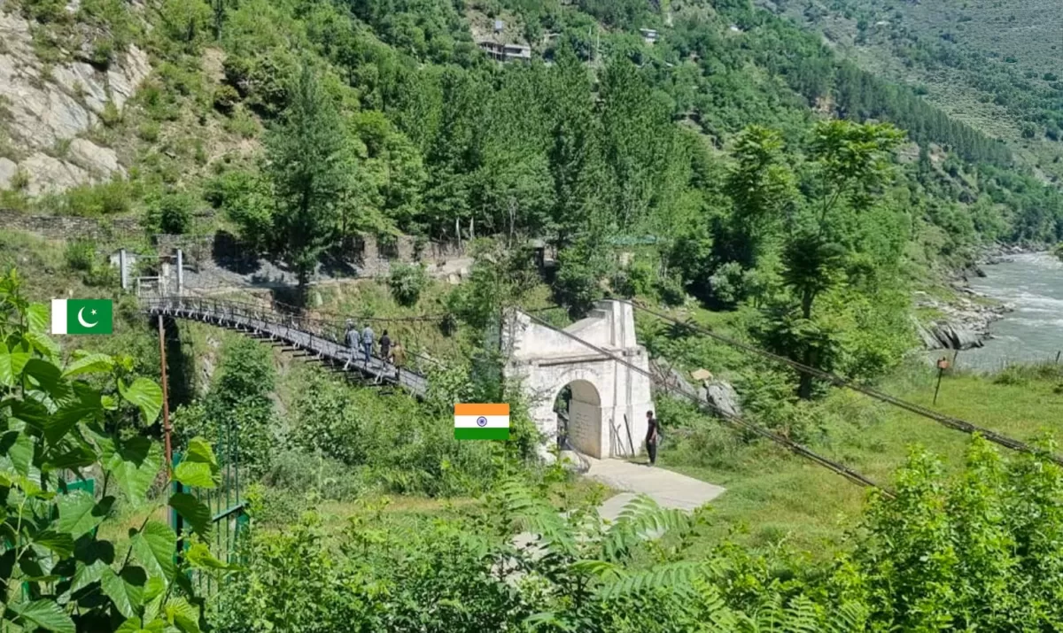 Teetwal Village LoC Tithwal bridge during sunny day Kashmir, featuring Indian Pakistani flags suspension bridge white gate people river pine hills backdrop, perfect Kashmir tour packages.