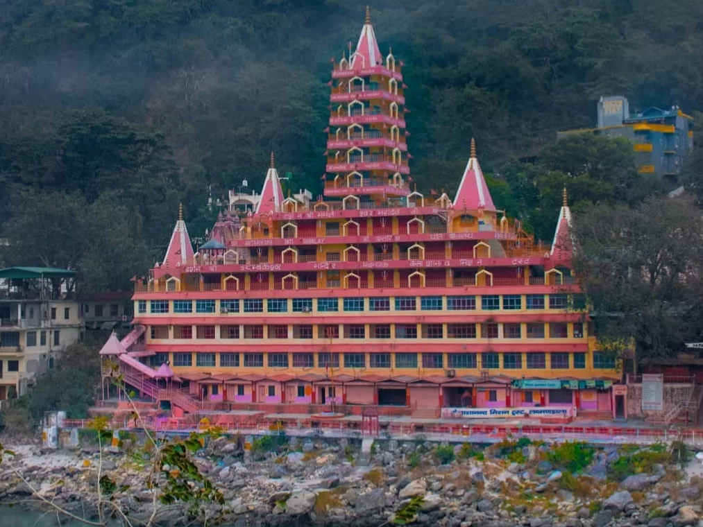 Tera Manzil Temple Rishikesh multi-storey Trimbakeshwar Temple on Ganga riverbank with vibrant pink architecture