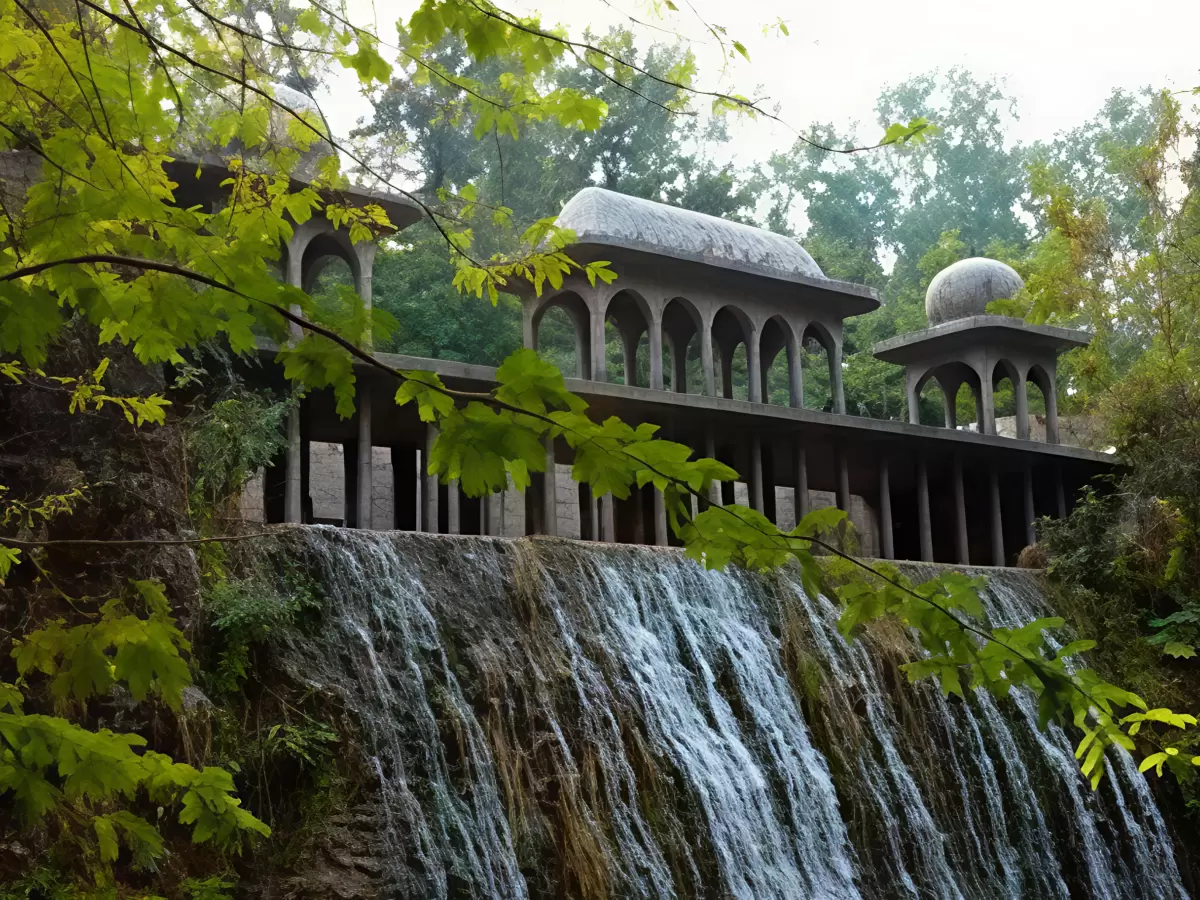 Architectural dome structures at Rock Garden Chandigarh during misty morning, featuring cascading waterfall, green trees, perfect cultural Himachal Pradesh tour package.