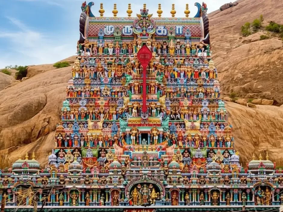 Thiruparankundram Murugan Temple ancient rock-cut cave architecture and the towering colorful gopuram carved directly into the massive granite hill near Madurai.