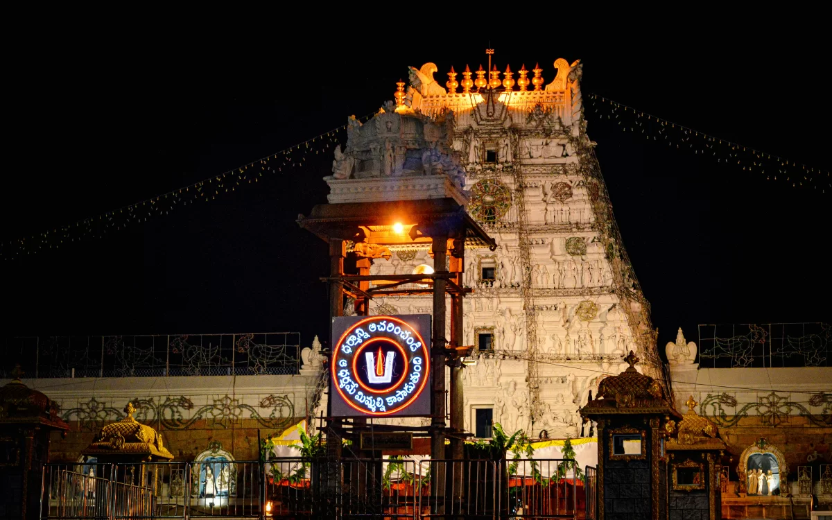 Gopuram at Tirumala Venkateswara Temple during night, featuring illuminated tower and TTD sign, perfect spiritual experience Tirupati tour package.