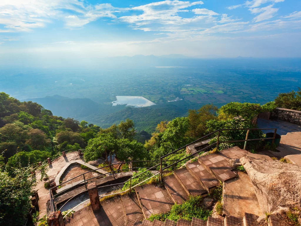 Toad Rock Sunset Point Mount Abu panoramic view, featuring stone steps railings lush green hills overlooking distant lake valley misty mountains golden light, perfect Rajasthan tour packages.
