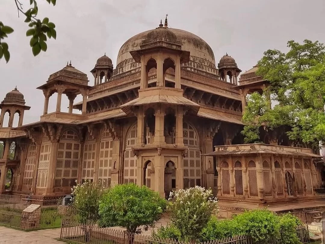 Tomb of Tansen in Gwalior featuring elegant Mughal-era architecture with domed pavilion and carved stone latticework, a cultural landmark included in Madhya Pradesh tour packages