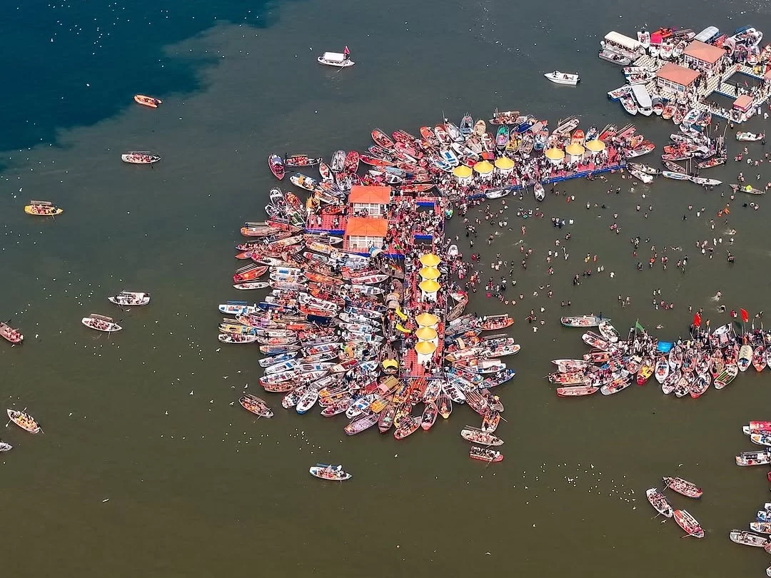 Triveni Sangam Prayagraj aerial festival, colorful boats tents crowd dark river, perfect Uttar Pradesh tour package.
