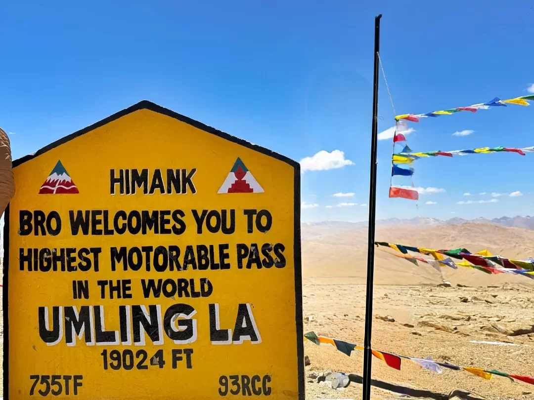 Umling La Pass Ladakh higher than Everest Base Camp under clear skies, featuring stickers and barren mountains, perfect adventure Ladakh tour package.