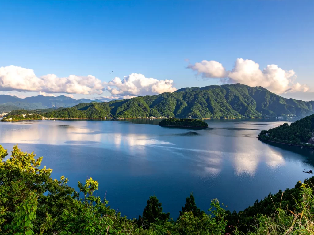 Valvan Lake View Point expansive turquoise lake forested emerald mountains islands clouds blue skies, perfect Lonavala Maharashtra nature tour packages.
