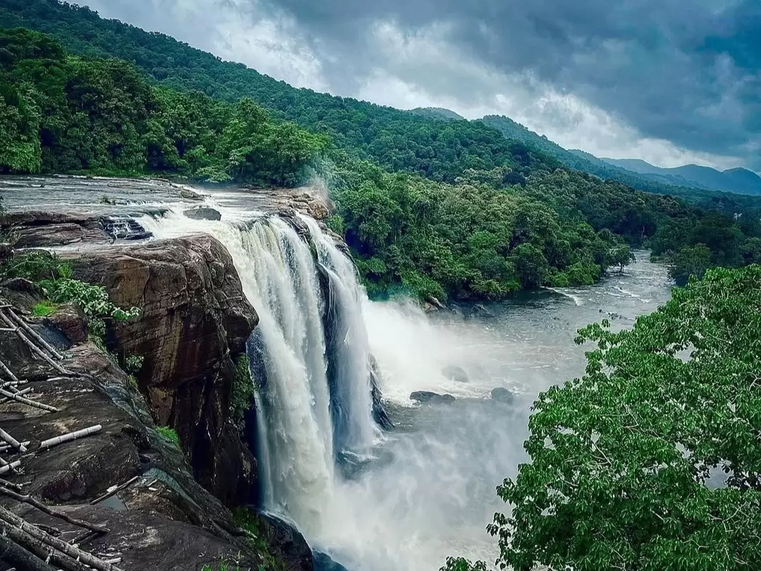 Vazhachal Waterfalls in Kerala, powerful cascades flowing through lush green forest landscape.