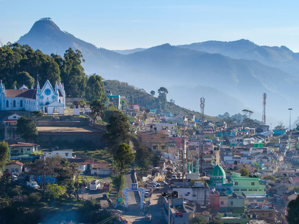 Poombarai village near Kodaikanal, featuring colorful hillside houses, church on the ridge and layered Western Ghats mountains in the background, perfect Tamil Nadu hill-station tour package