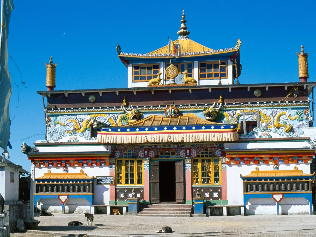 Yiga Choeling Monastery in Darjeeling during sunny daytime, featuring ornate Tibetan facade and clear blue sky, perfect spiritual Darjeeling tour package
