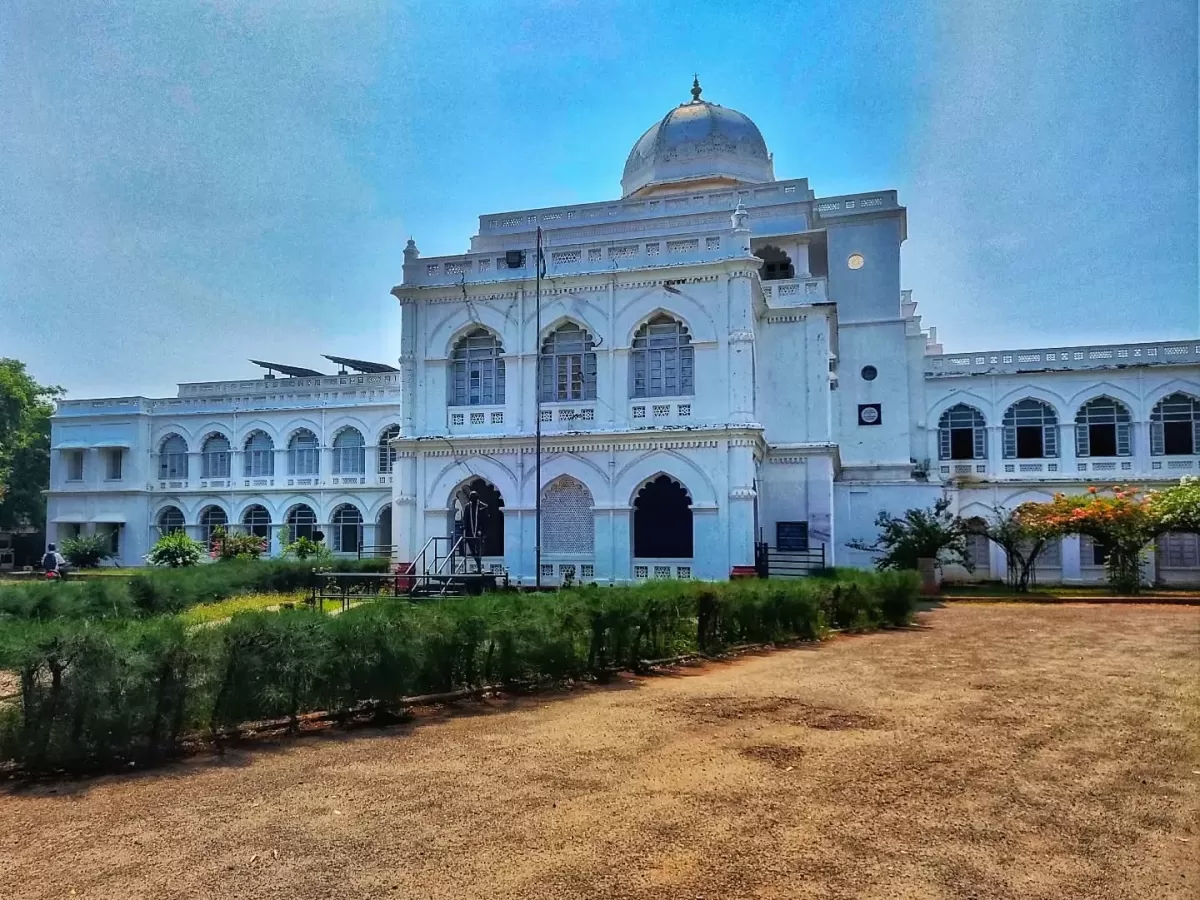 Exterior of Gandhi Memorial Museum Madurai Tamil Nadu India housed in historic Tamukkam Palace white Indo-Saracenic architecture dome arches lawns trees blue sky, former residence of Rani Mangammal Nayak dynasty.